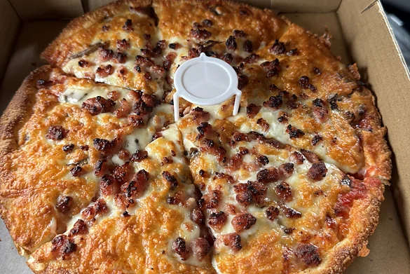 Bacon pizza in an open takeout box