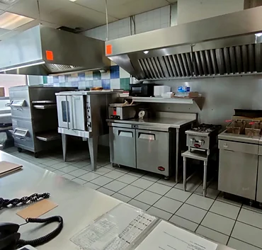 Clean stainless-steel kitchen with pizza ovens at Nitza's Pizza